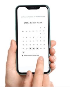 Hand die Smartphone hält, die andere tippt darauf - Terminplanung Screen